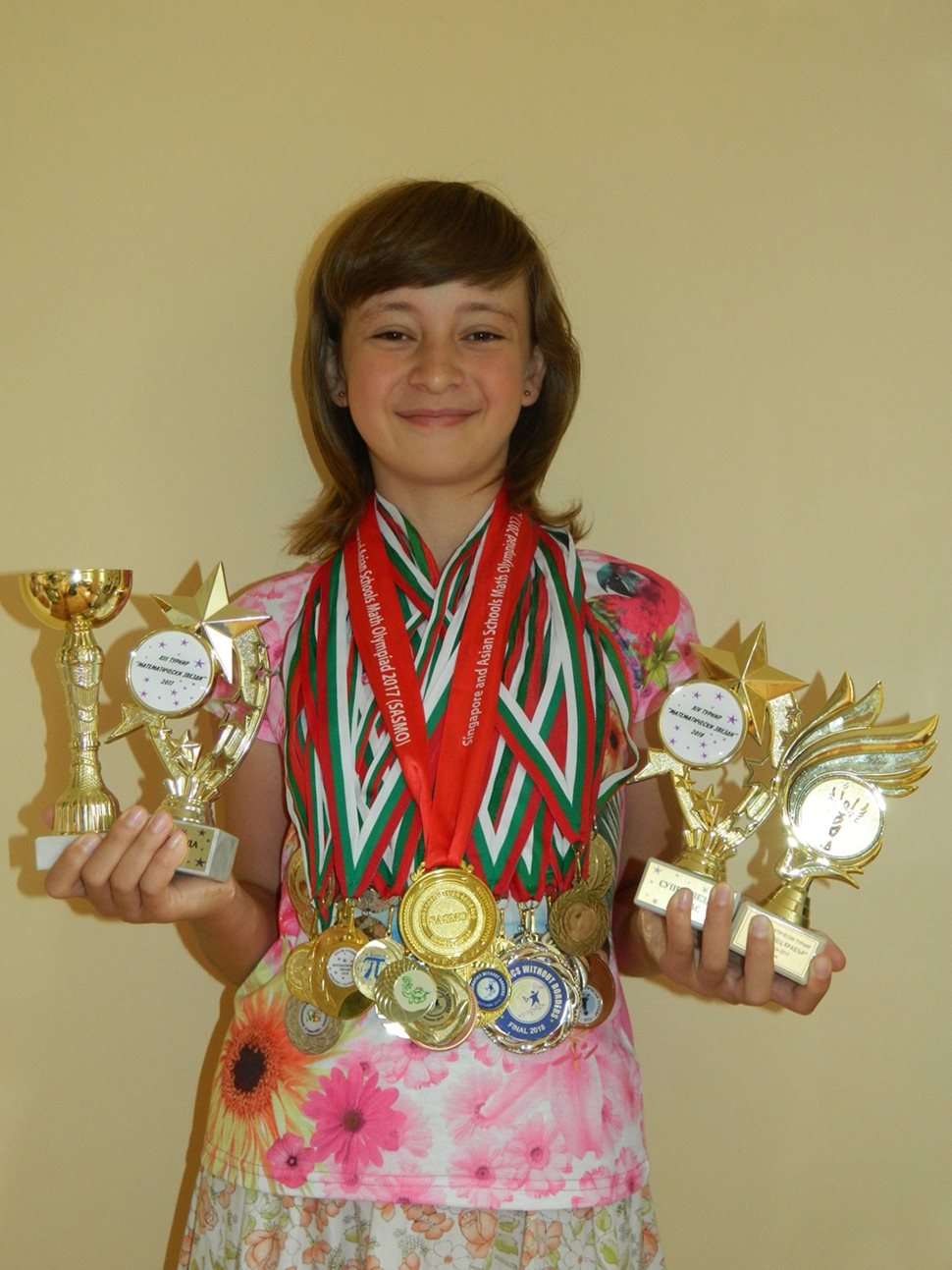 Сара показва част от  купите и медалите, които е спечелила.