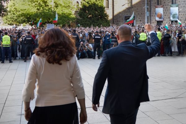 Президентът Румен Радев с вдигнат юмрук и вицепрезидентът Илияна Йотова излизат пред протестиращите срещу правителството.  