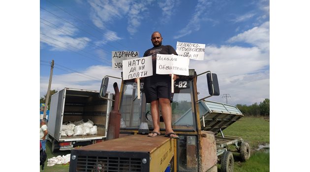 Земеделски производител се качи на трактор да протестира с плакати.