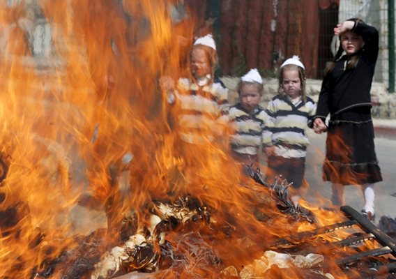 Деца в еврейския квартал на Йерусалим наблюдават ритуален огън, в който преди Пасха се изгарят всички остатъци, по които би могло да има следи от храна с квас