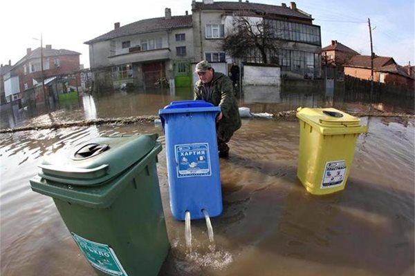 Мъж от Елхово мести контейнер за боклук, от който изтича вода. 
СНИМКИ: РОЙТЕРС И БУЛФОТО