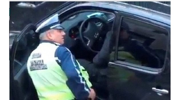 Кадър от видео с пътен полицай Сашо Тръпков в момент, в който взима подкуп.