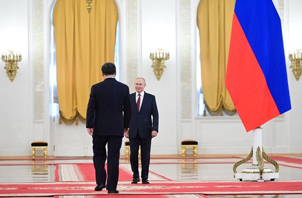 Двамата лидери влязоха в огромната зала с полилеи от противоположни страни и се ръкуваха в средата ù, а през това време звучаха националните химни на Русия и Китай.