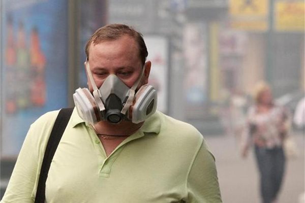 Московчанин се опитва да се предпази от мръсния въздух със специална пречистваща маска на устата и носа.