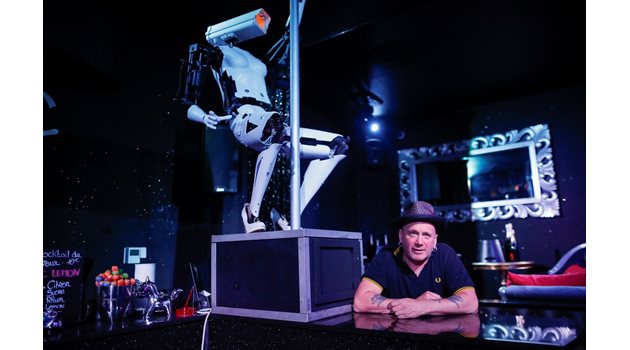 Британският художник Джайлс Уокър позира до своя робот, танцуващ на пилон, по време на монтирането му в стриптийз клуб във френския град Нант.