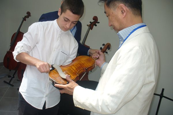 Китайският лютиер Дзенг Куан поднася на младия български цигулар Александър Тянов 300-годишната цигулка на италианския майстор Джузепе Гуарнери.