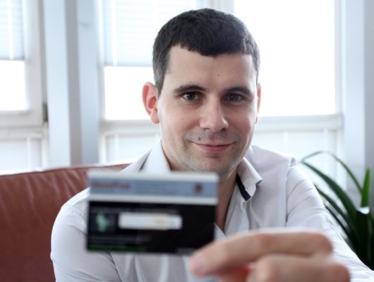 Георги Кънев държи банкова карта със залепен на нея стикер SkimProt