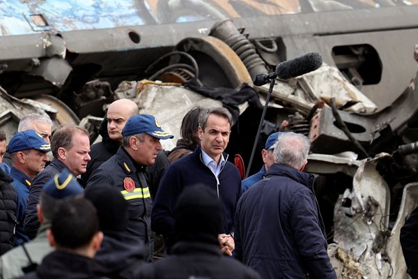 Гръцкият премиер Кириакос Мицотакис оглежда мястото на катастрофата, близо до град Лариса.