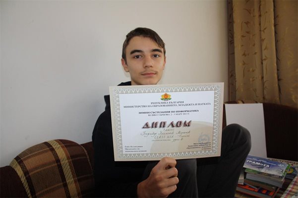 Божидар покзва диплом от МОН за спечелено I място, подписан от бившия зам.-министър на образованието Милена Дамянова.