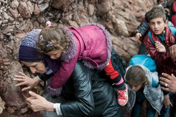 Жена носи детето си на ръце, след като пристига на остров Лесбос/Октомври