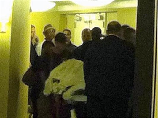 Парамедици изнасят тялото на Уитни от хотела.