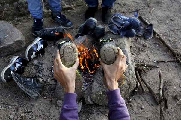 Момче суши обувките си във временен лагер на остров Лесбос/Октовмри