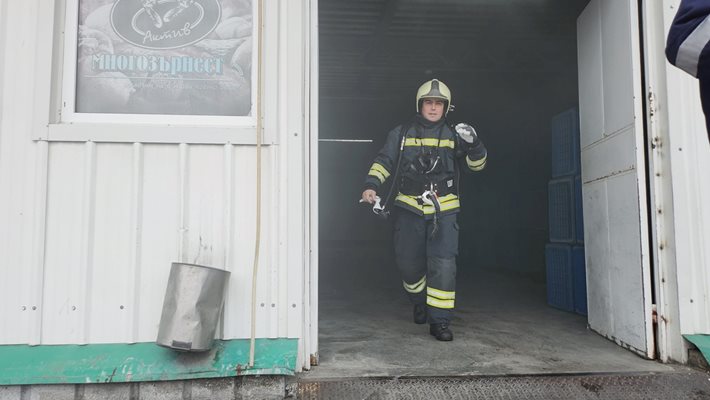 Пожарникар излиза от спасената сграда на хлебозавода.