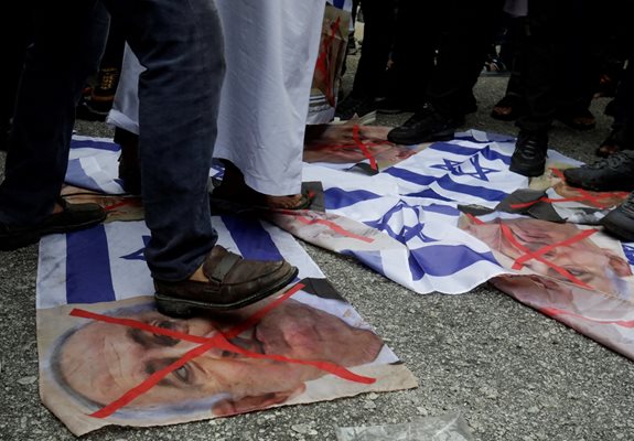 Пропалестински демонстранти тъпчат израелския флаг и портрета на премиера Нетаняхул Снимка: Ройтерс