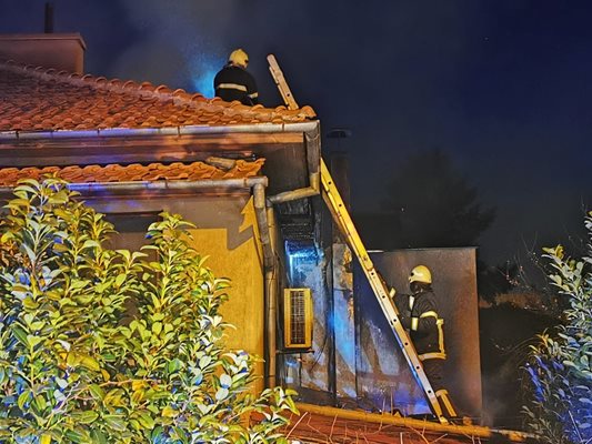Пожарникарите на покрива на къщата.