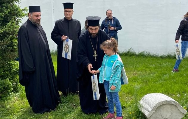 Отец Васил връчи подарък - книжка, на малката Рая.