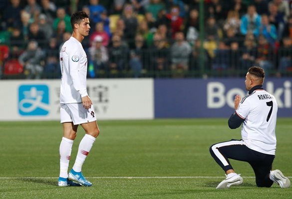 Фен е коленичил пред Кристиано Роналдо на стадиона във Вилнюс, за да изрази възхищение от любимеца си. Португалецът се снима с него.