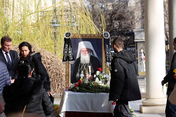 След като хвърлят пръст, хората минават пред портрета на патриарха да се прекръстят.