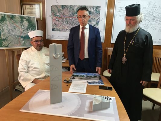 Кметът на Кърджали Хасан Азис, енорийският свещеник отец Петър Гарена и районният мюфтия Басри Еминефенди показват как ще изглежда паметникът, който ще бъде изграден в центъра на града. СНИМКА: НЕНКО СТАНЕВ