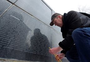 Мъж пали свещ в деня за възпоминание на жертвите от комунизма. Снимка Архив