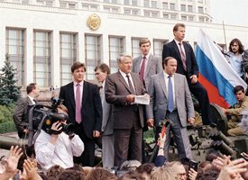 Борис Елцин е качен върху бронетранспортьор пред Белия дом в Москва и изнася реч към руския народ. Под него са журналисти, подали микрофони, а един от тях държи чука от “Стената”. Тази снимка беше на 19-а стр. в броя на “24 часа” от 21 август.