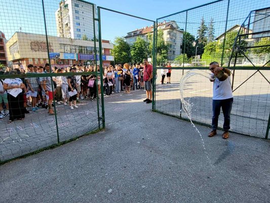 Директорът на 119-о училище Диян Стаматов полива вода за успех на учениците преди началото на изпита.