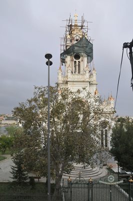 Работници поставят златно покритие на купола на църквата.