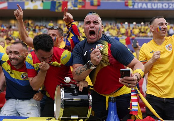 Romanian fans cheer at the stadium in Cologne before the match.  PHOTO: Reuters