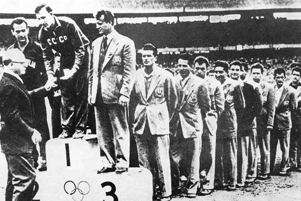 Българите на олимпийската почетна стълбичка в Мелбърн, водени от капитана Божков