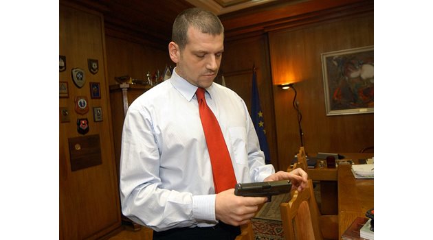 Като главен секретар показва пистолет, с който е бил награден.