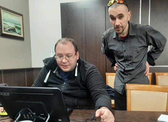 Експертът на община Бургас Красимир Червенков (правият) показва как се използва устройството.