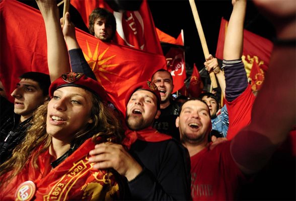 Здрави младежи приветстват своите лидери по време на митинг в Скопие.