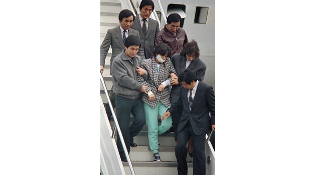 Атентаторката Ким слиза от самолета в Сеул, за да бъде осъдена на смърт и по-късно помилвана.