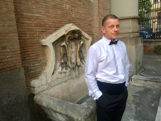 Актьорът Юлиан Вергов позира пред антична чешма в българското посолство в Рим