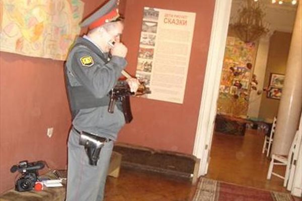 Въоръжен с автомат милиционер охранява експозицията. 