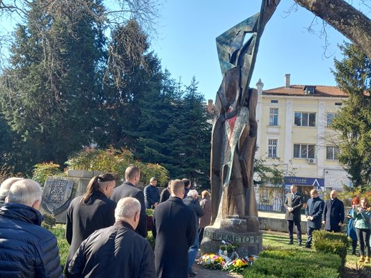 Присъстващите на церемонията поднасят венци и цветя пред паметника на репресираните.