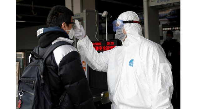 Медицински работник проверява температурата на пътник на летището в град Чанша.