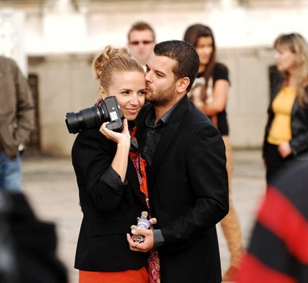 Иван целува нежно Ирина, докато тя  снима абитуриентите пред “Св. Александър Невски” през 2012 г.
