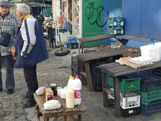 Търговец продава на открито прясно мляко, сирене, кашкавал и яйца.