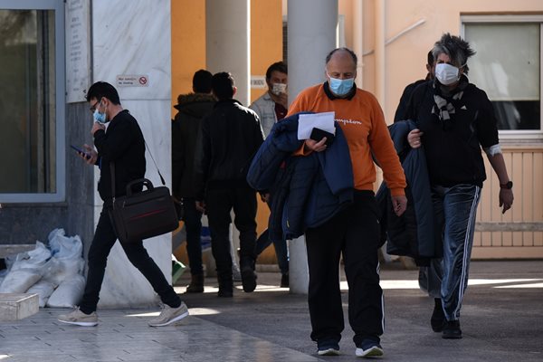 Хора с предпазни маски излизат от болницата в Солун, в която лежи заразената с коронавирус гъркиня, върнала се от Северна Италия.