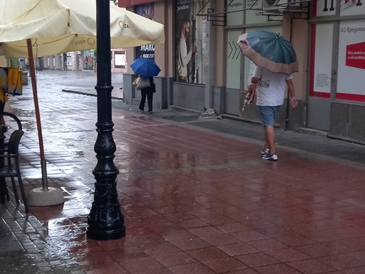 Пешеходци с чадъри в центъра на Пловдив. Снимка: Архив