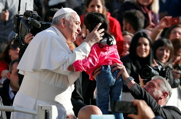 Папата целува дете пред множеството, събрало се на традиционната обща аудиенция. Снимка РОЙТЕРС