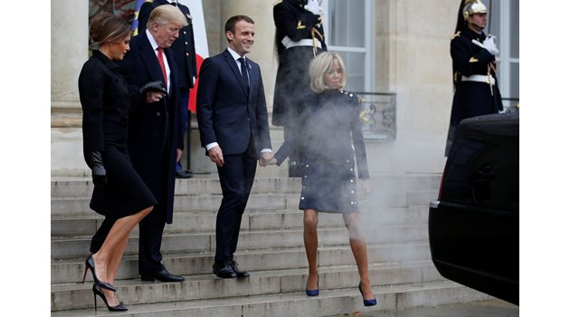 Първата дама на Франция Брижит Макрон (вляво) е обгърната в пушек и изгорели газове от кадилака на Доналд Тръмп при пристигането на президентската двойка на САЩ в Елисейския дворец.