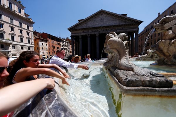Туристи се плискат с вода от обществен шадраван в центъра на Рим, където властите налагат глоби за влизане в подобни водоизточници.