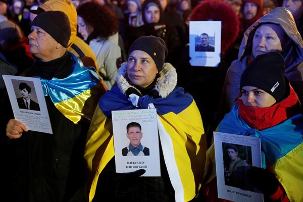 Редица протестиращи държат снимки на хора, загинали по време на масовите антиправителствени демонстрации в Украйна през 2014 г.