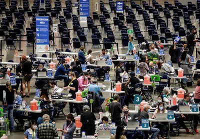 Hundreds of people received injections during a mass vaccination in Seattle, Washington.  More than 100 million doses have been administered in the United States.  PHOTO: Reuters