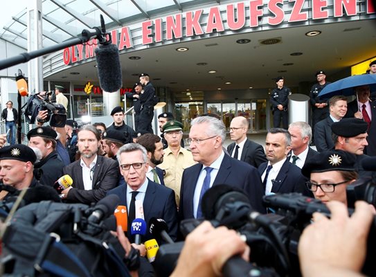 Германският вътрешен министър Томас де Мезиер говори пред търговския център “Олимпия” в Мюнхен, където ученикът изби 9 души и рани десетки.