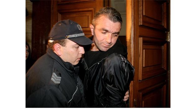 НА СЪД: Полицай охранява Будимир Куйович при едно от поредните му дела.