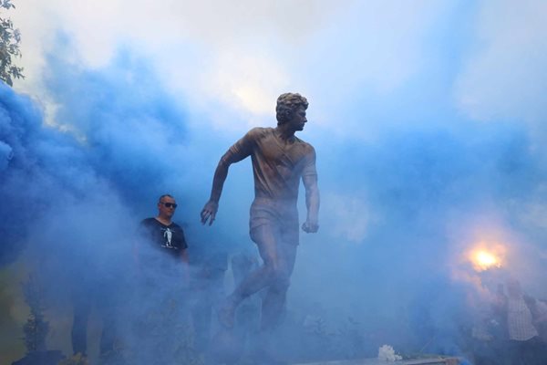 Величествената фигура на Георги Аспарухов сякаш излиза от синия дим по време на официалното откриване на паметника на Гунди в близост до родната му къща в София. СНИМКИ: НИКОЛАЙ ЛИТОВ