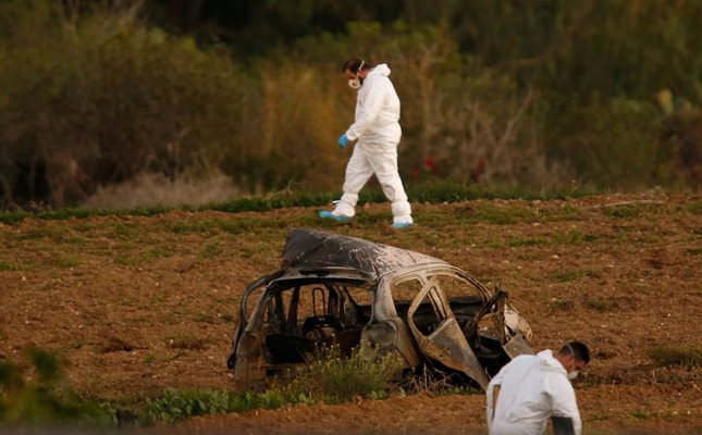 Следователи оглеждат полето, където бе взривена колата на малтийската журналистка.  СНИМКИ: РОЙТЕРС